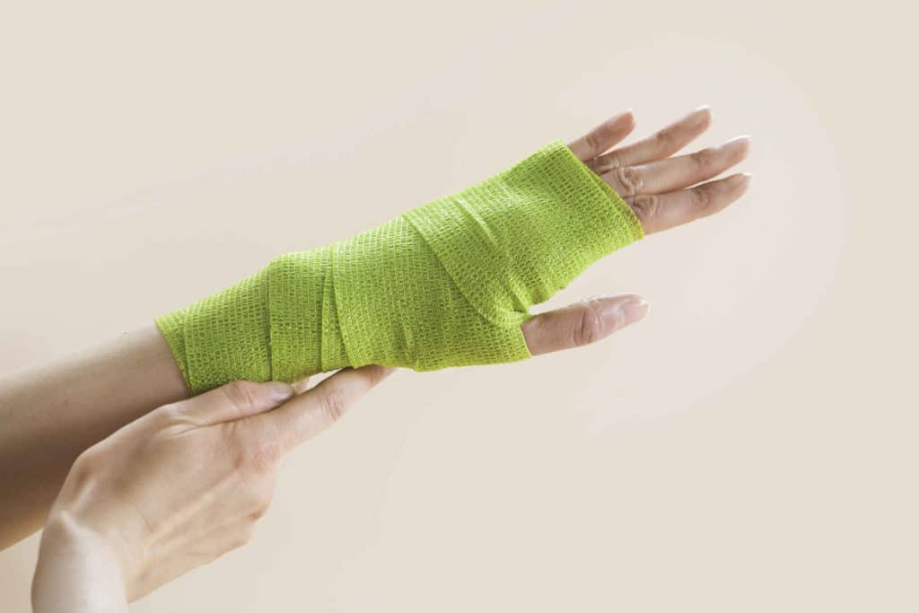 Käsi, joka on kääritty vihreään sideharsoon.