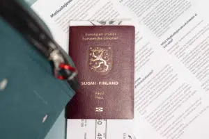 Suomen passi, lentolippu ja moniste, jossa on tekstiä.