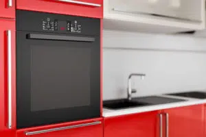 Erillisuuni keittiössä, jossa on punaiset keittiökaapit.