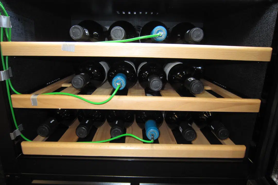 Viinikaapissa on viinipulloja ja lämpömittareita.