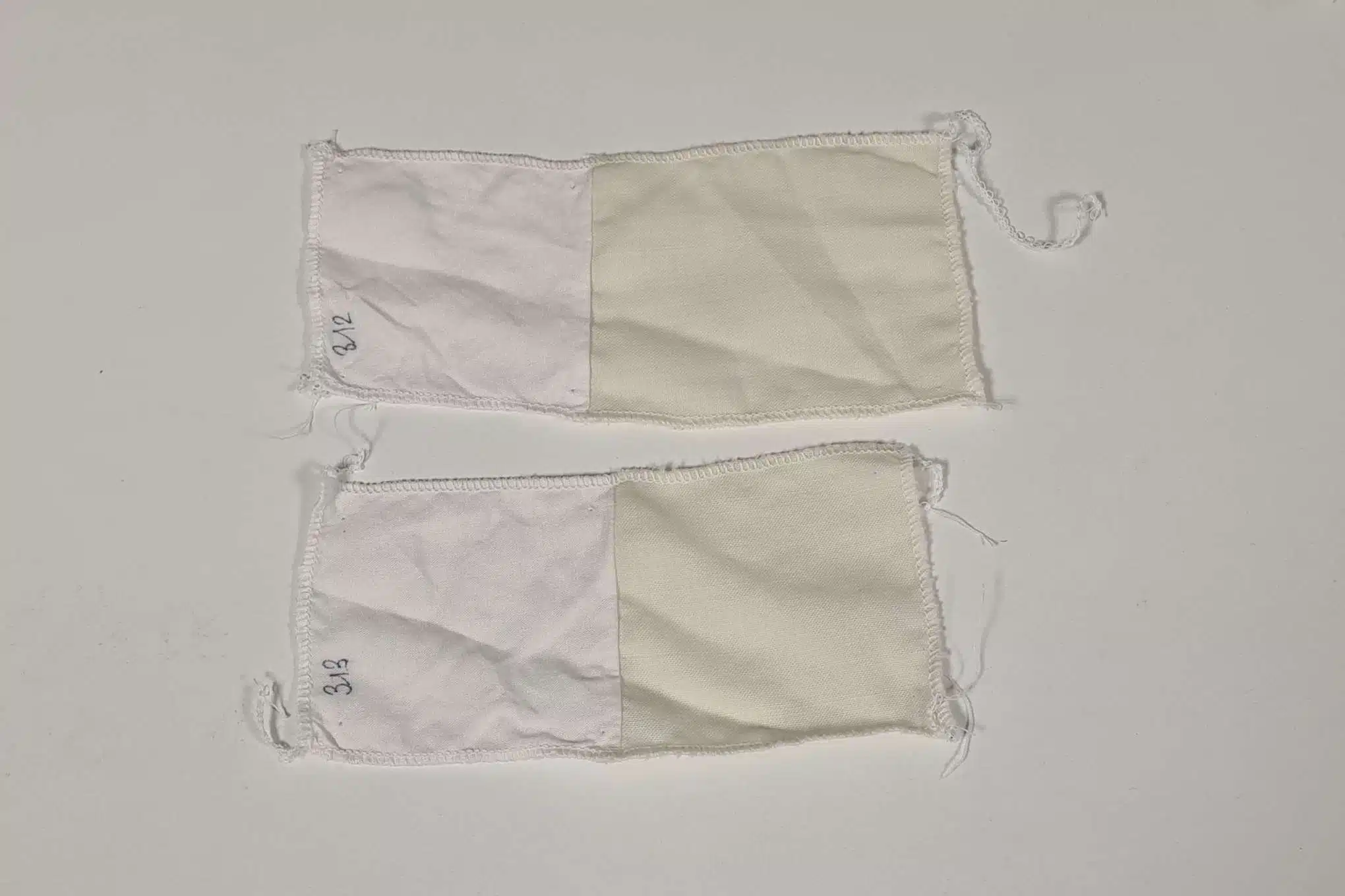 Kaksi kangaspalaa, joissa on kahta erilaista valkoisen sävyä.