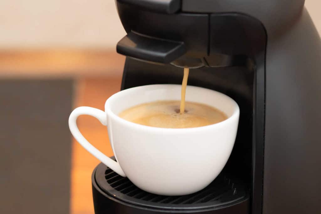 Kapselikahvikone valmistamassa juomaa kahvikuppiin.